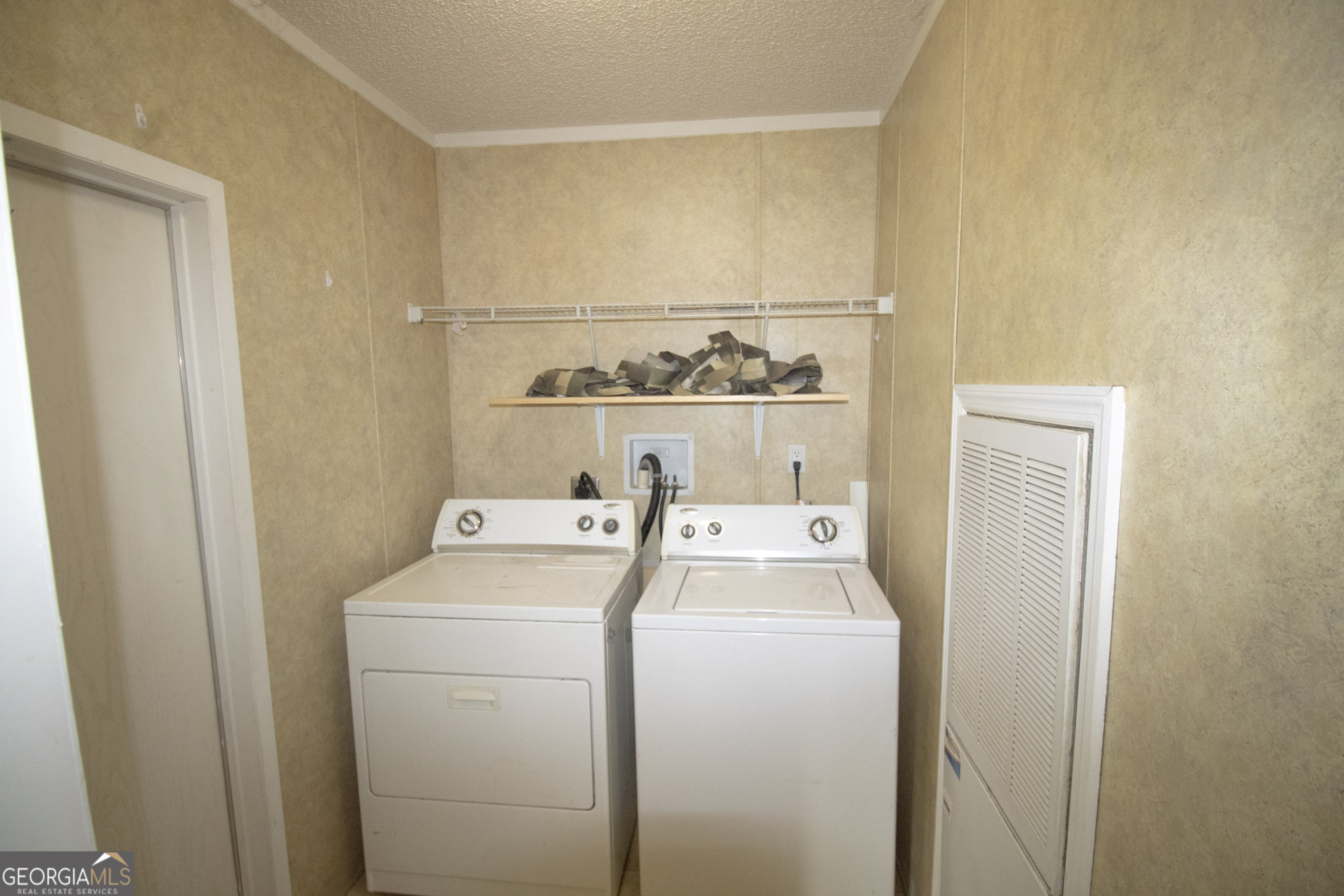1776 Zettwell Road Statesboro, GA 30461 - Photo 7 of 20 a view of washer and dryer with kitchen in the background