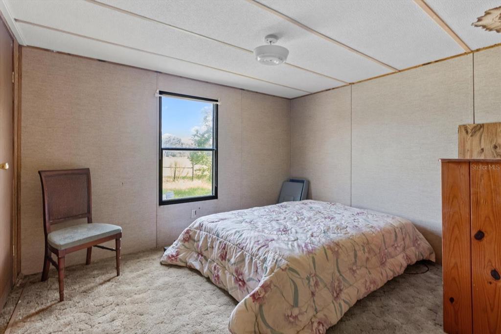 6177 County Road 625 Bushnell, FL 33513 - Photo 26 of 93 a bedroom with a bed window and a chair