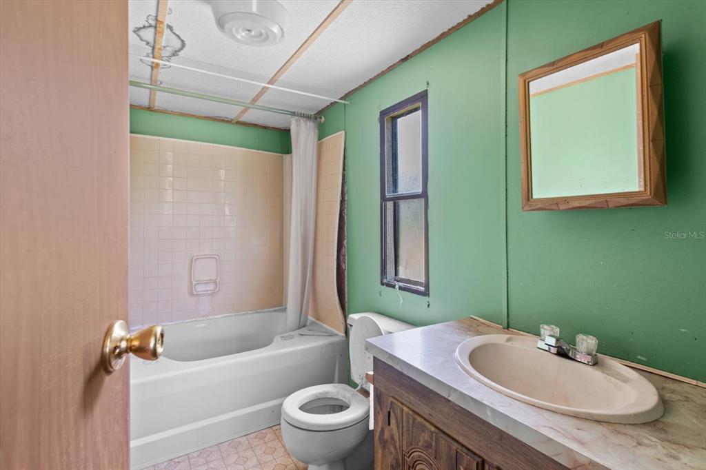 6177 County Road 625 Bushnell, FL 33513 - Photo 28 of 93 a bathroom with a granite countertop sink toilet a mirror and bathtub