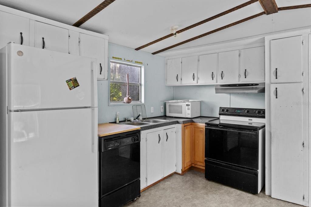 6177 County Road 625 Bushnell, FL 33513 - Photo 64 of 93 a kitchen with stainless steel appliances granite countertop white refrigerator stove a sink and dishwasher
