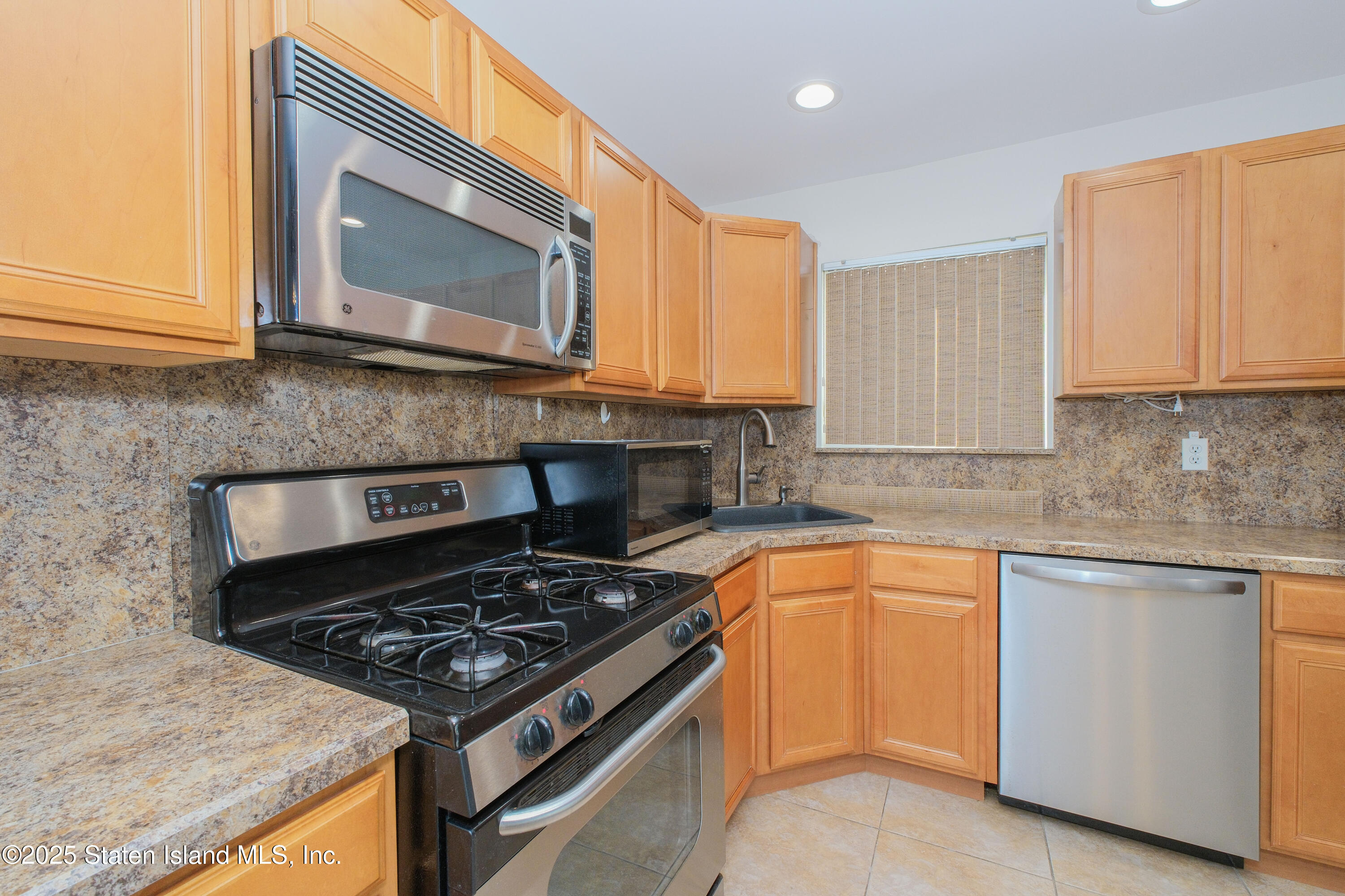 49 Endview Street Staten Island, NY 10312 - Photo 13 of 38 a kitchen with stainless steel appliances granite countertop a stove a sink and a microwave