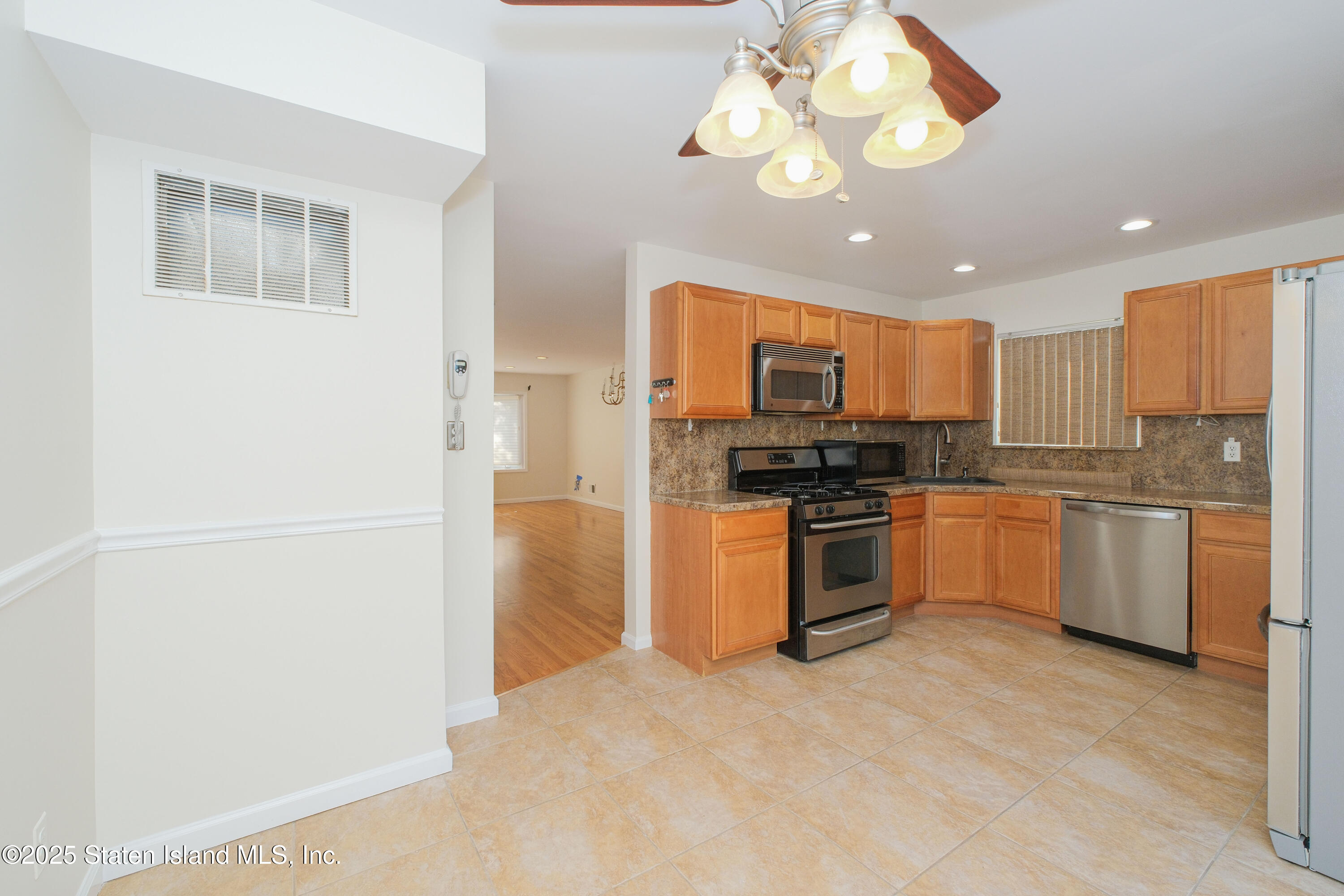 49 Endview Street Staten Island, NY 10312 - Photo 14 of 38 a kitchen with a refrigerator chandelier and white cabinets
