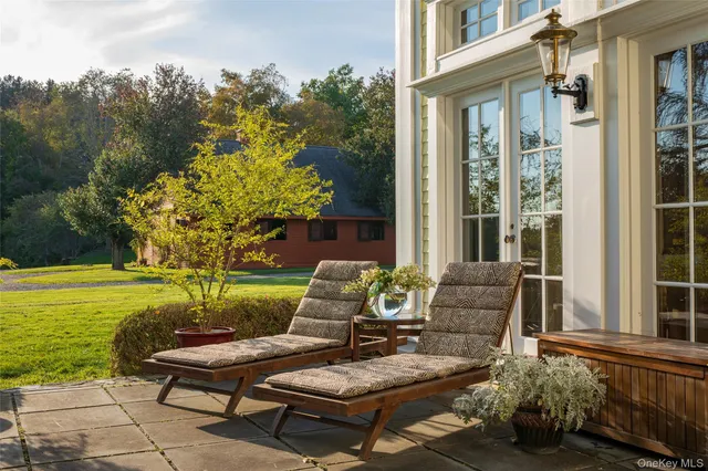 a view of a patio with couches table and chairs and potted plants