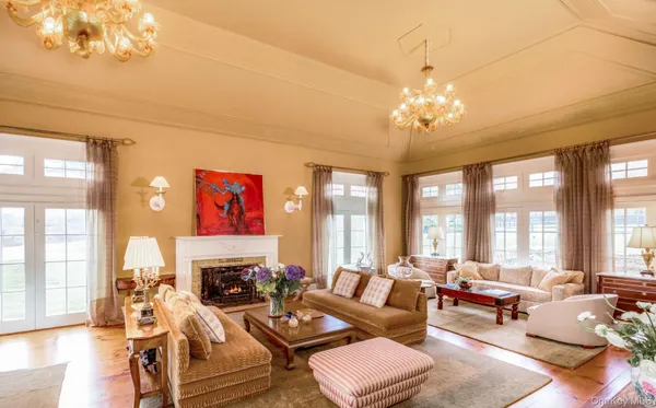 a living room with fireplace furniture and a large window