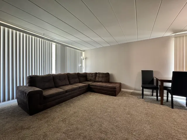 a living room with furniture and a piano