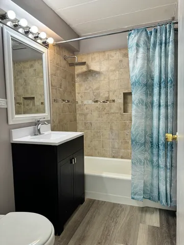 a bathroom with a sink a toilet a mirror and shower