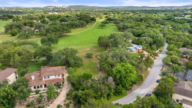 an aerial view of residential houses with outdoor space and trees