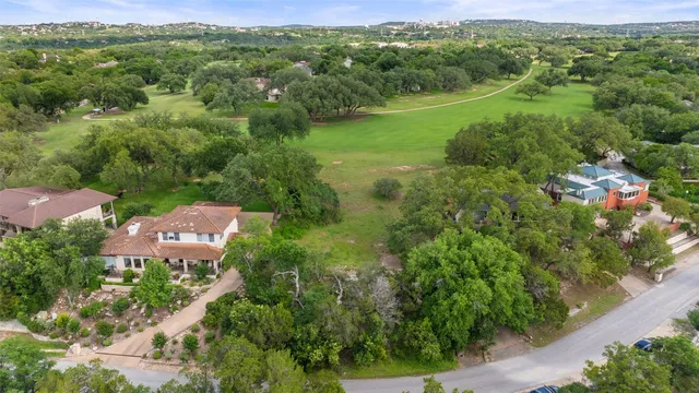 an aerial view of residential houses with outdoor space and trees