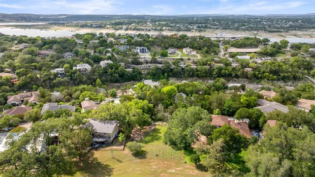 an aerial view of a houses with a yard and lake