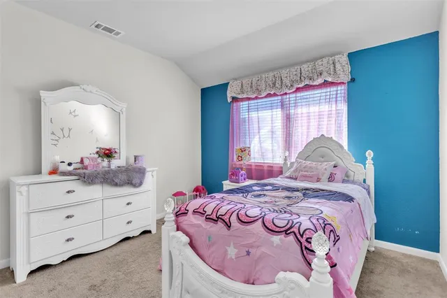 a bedroom with a bed and a dresser in it