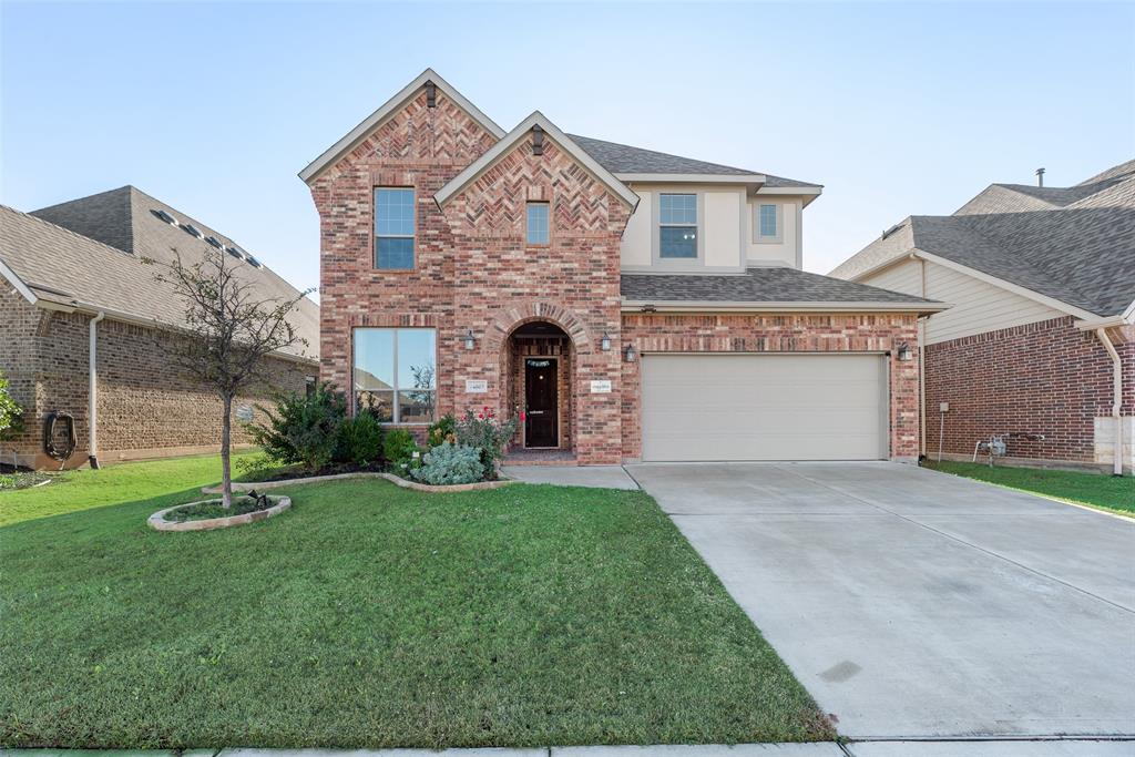 Traditional home with concrete driveway, a front lawn, brick siding, and a shingled roof