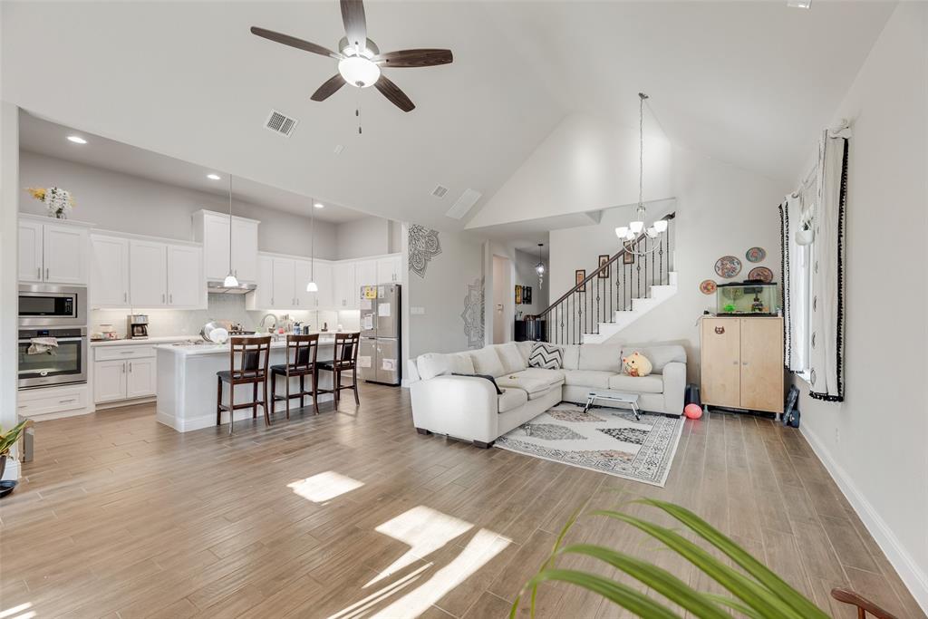 14809 Cedar Flt Way Fort Worth, TX 76262 - Photo 4 of 18 Living room with a ceiling fan, high vaulted ceiling, wood finish floors, stairs, and a chandelier