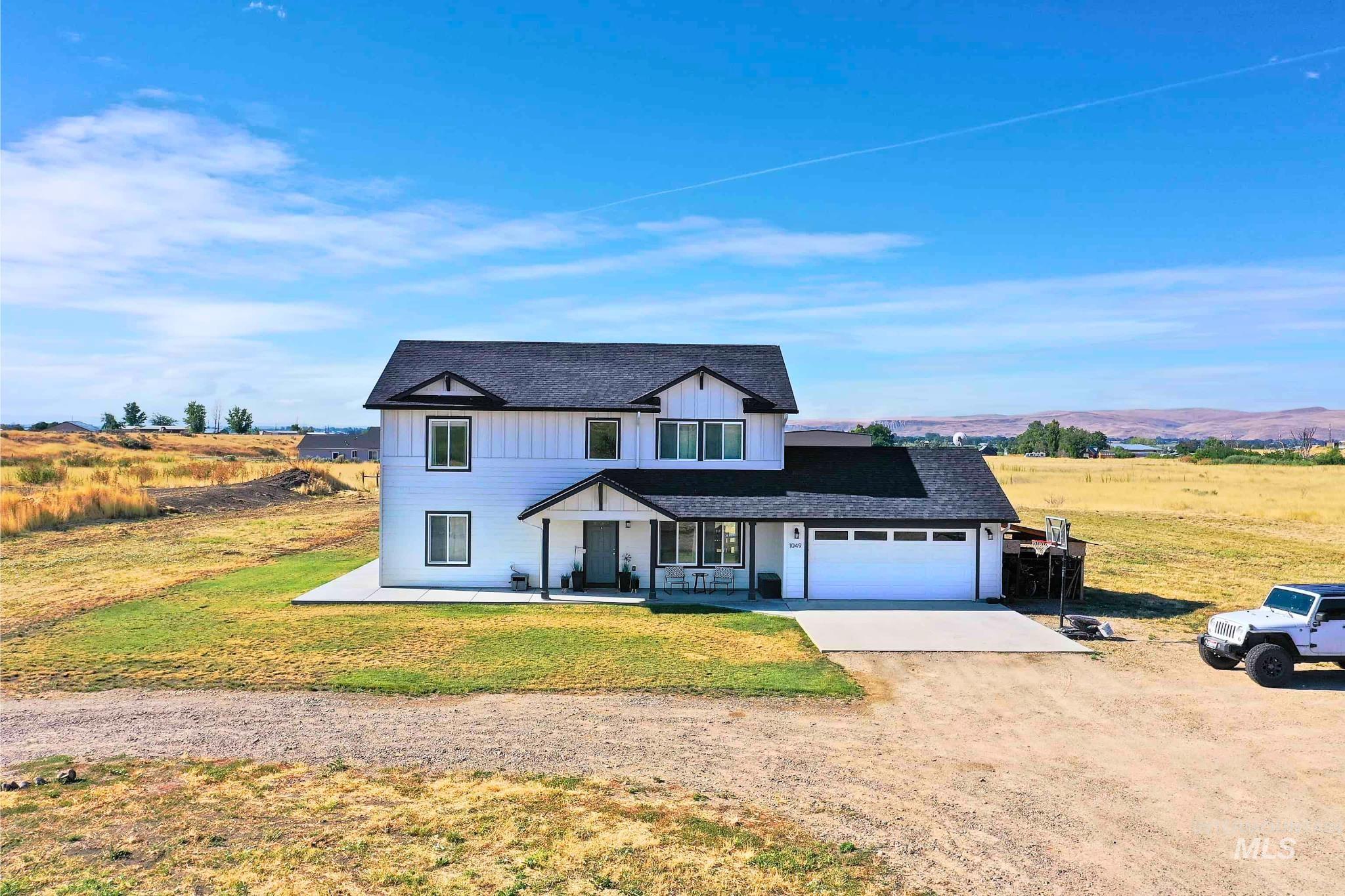 1049 Price Road Weiser, ID 83672 - Photo 37 of 47 Two-story white exterior with dark trim and a covered front porch