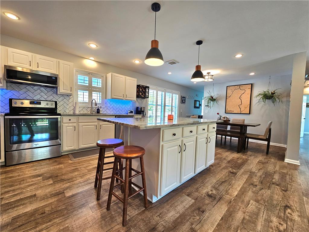 190 Canal Road Easton, PA 18042 - Photo 5 of 39 a kitchen with stainless steel appliances granite countertop a stove top oven a sink a dining table and chairs with wooden floor