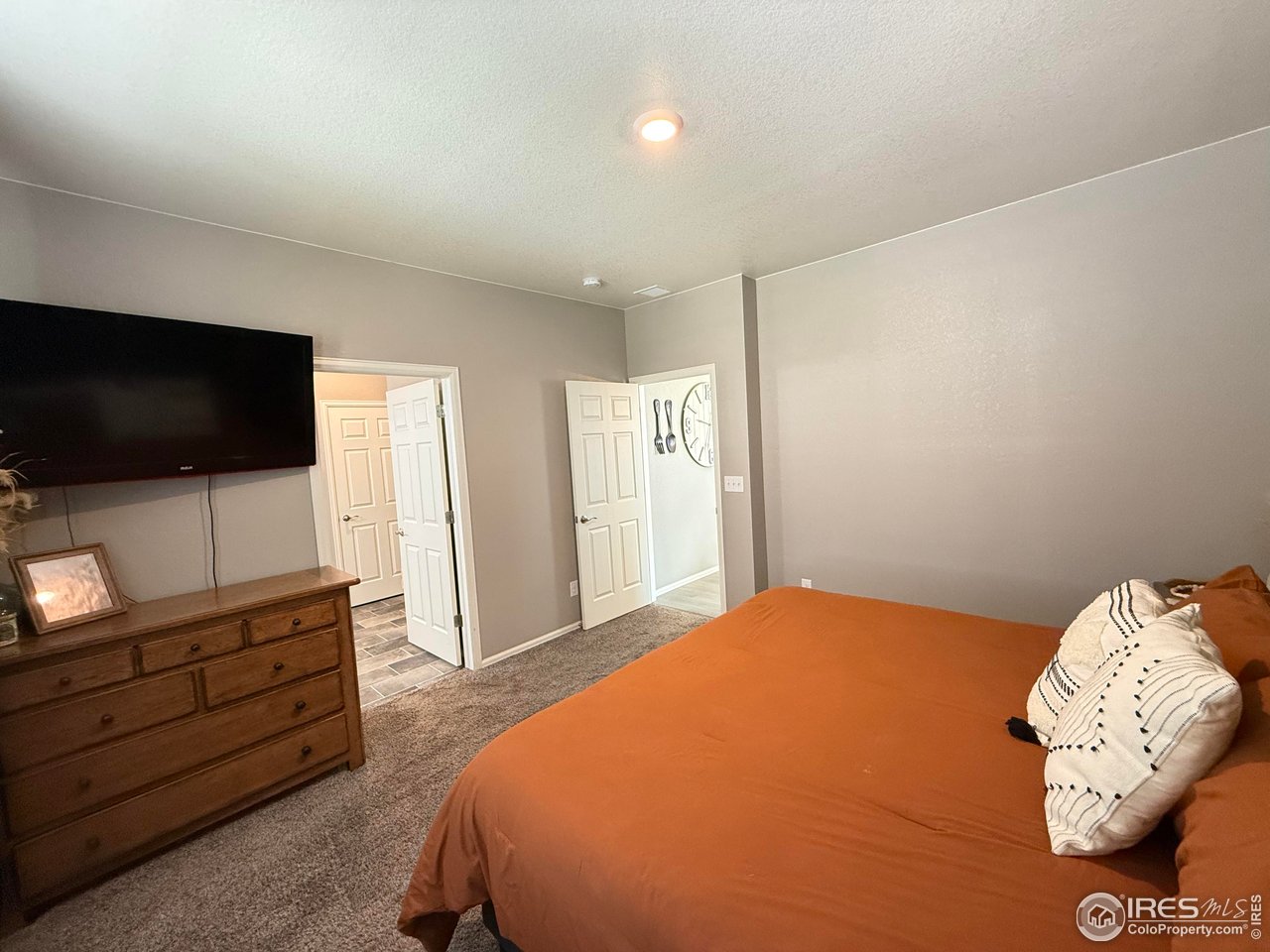 1780 Floret Drive Windsor, CO 80550 - Photo 15 of 36 a bedroom with a bed and a flat screen tv