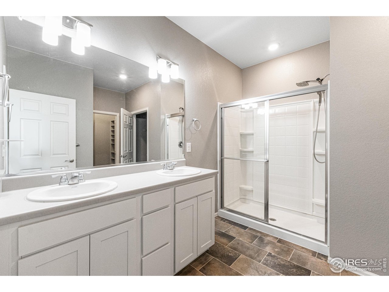 1780 Floret Drive Windsor, CO 80550 - Photo 17 of 36 a bathroom with a double vanity sink mirror and shower
