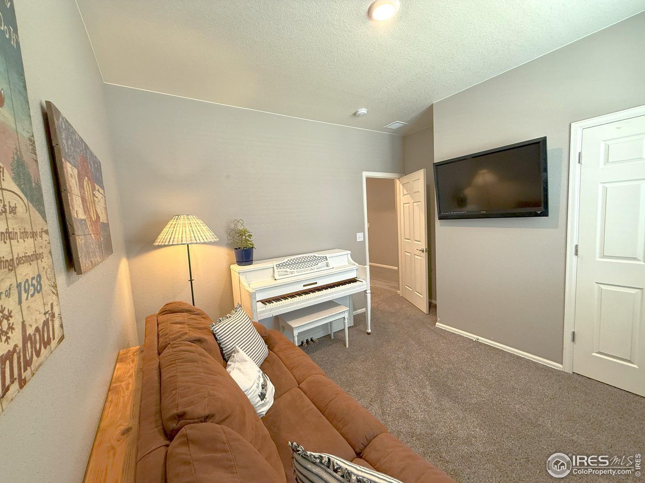 1780 Floret Drive Windsor, CO 80550 - Photo 19 of 36 a bedroom with a bed and a flat screen tv
