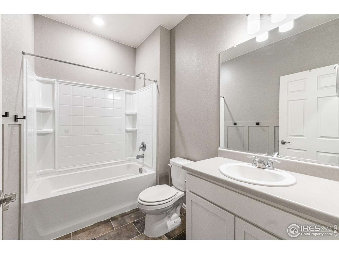 1780 Floret Drive Windsor, CO 80550 - Photo 25 of 36 a bathroom with a sink a toilet and a large mirror