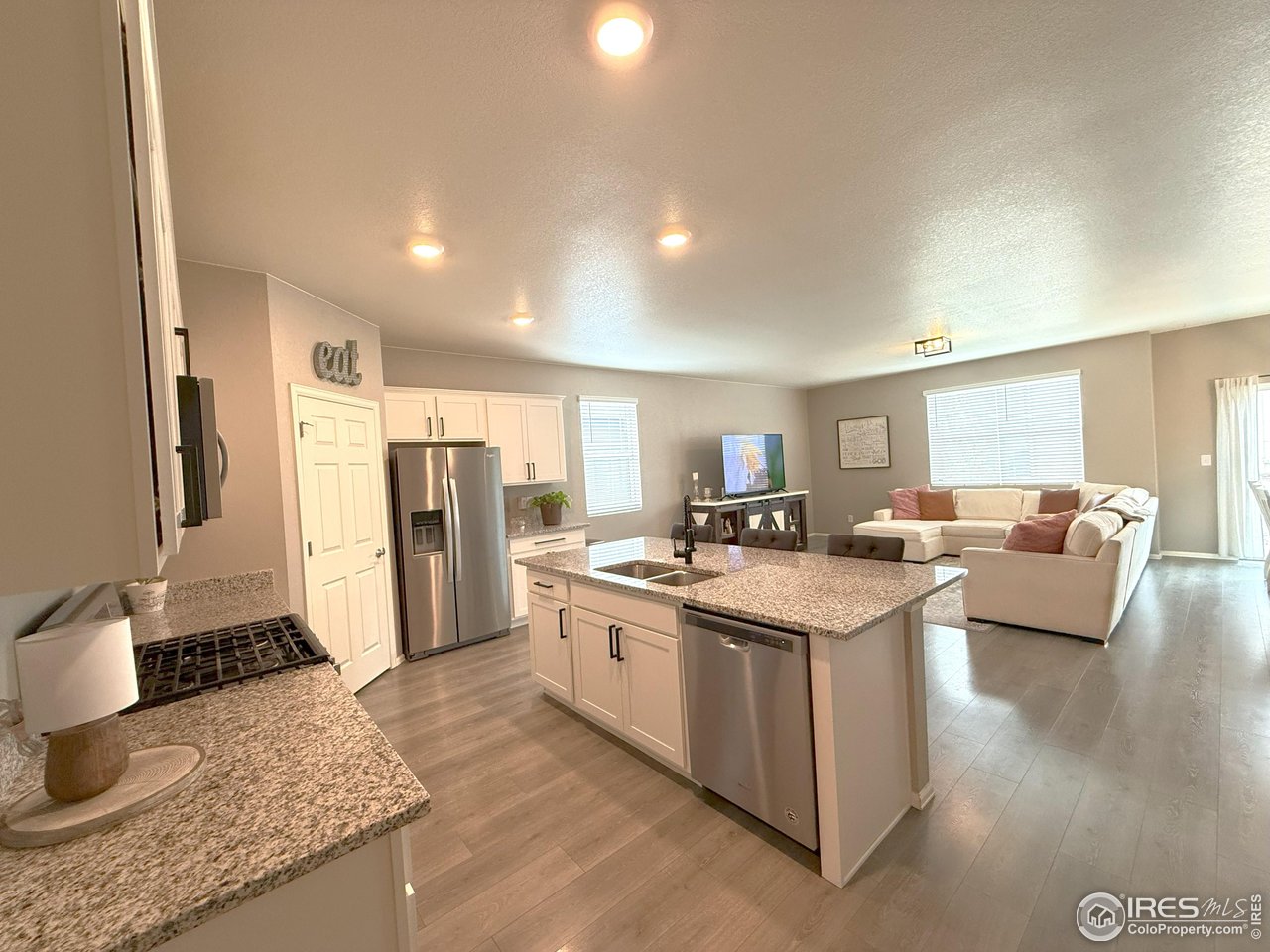 1780 Floret Drive Windsor, CO 80550 - Photo 7 of 36 a kitchen with stainless steel appliances granite countertop a sink stove and refrigerator