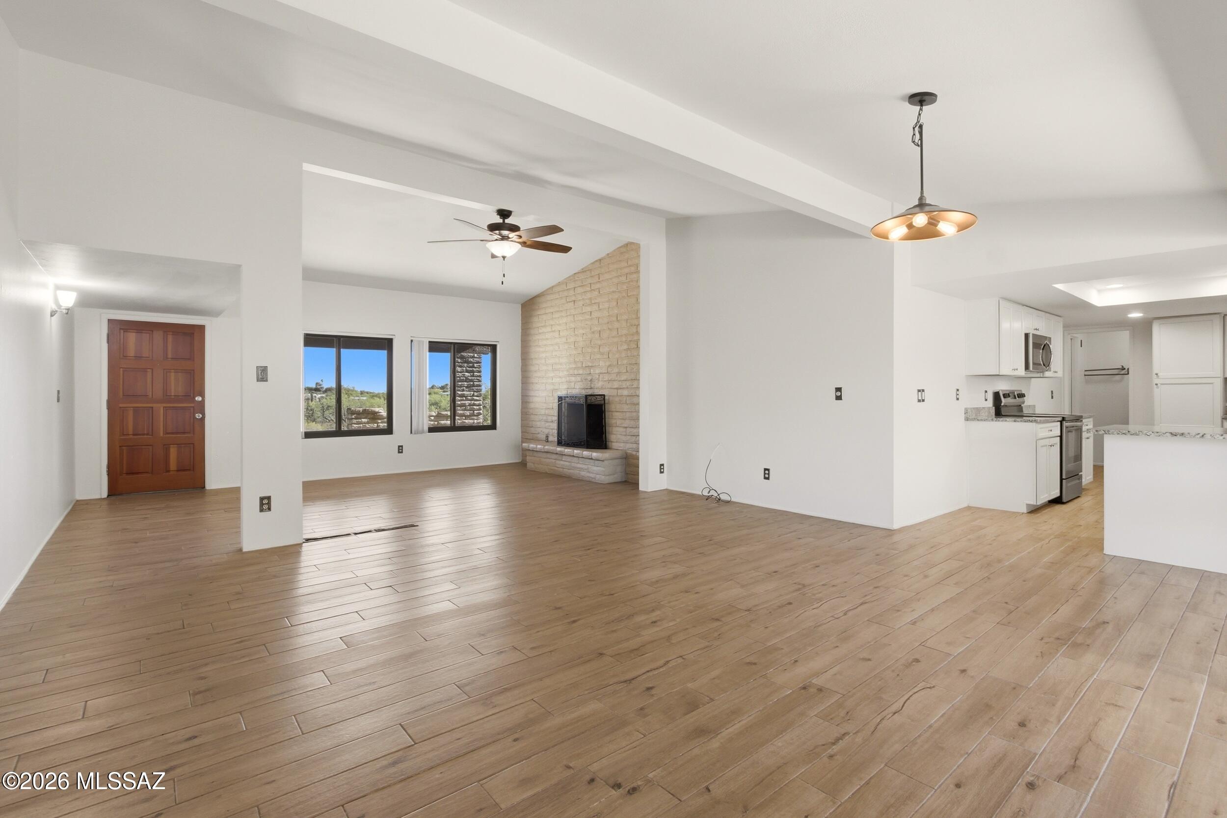 9141 East Indian Canyon Road Tucson, AZ 85749 - Photo 9 of 33 a view of a livingroom with wooden floor and a ceiling fan