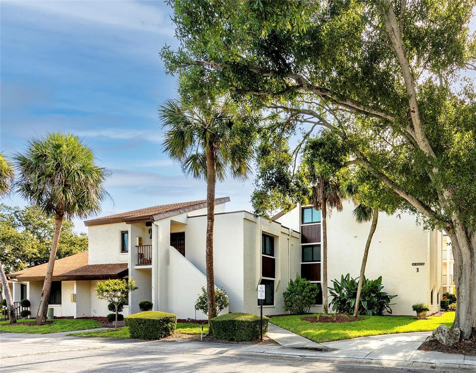 2207 Belleair Road, Unit B4 Clearwater, FL 33764 - Photo 33 of 37 a view of a white house with a tree and a yard
