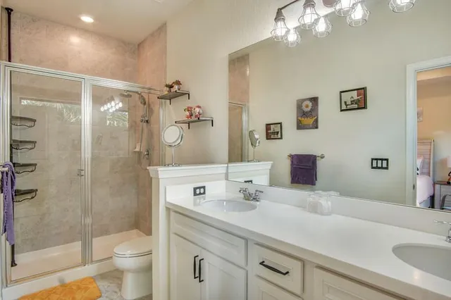 a bathroom with a sink a toilet and shower