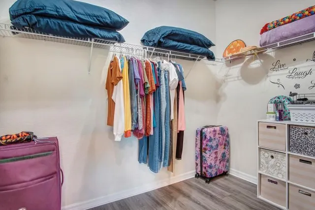 a view of walk in closet with clothes and shoes