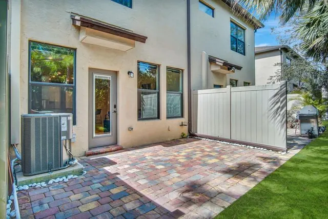 a view of backyard with large windows and plants