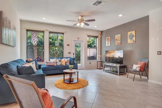 a living room with furniture a flat screen tv and a large window