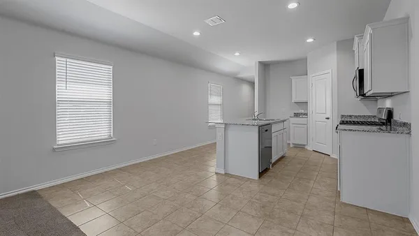 a kitchen with stainless steel appliances granite countertop a refrigerator and a stove top oven