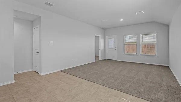 a open kitchen with white cabinets and a refrigerator