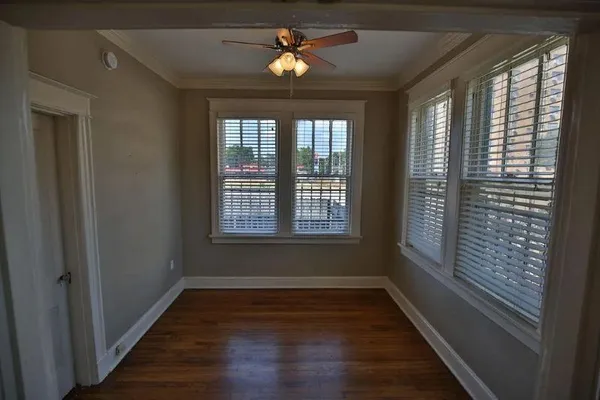 a view of empty room with wooden floor and fan