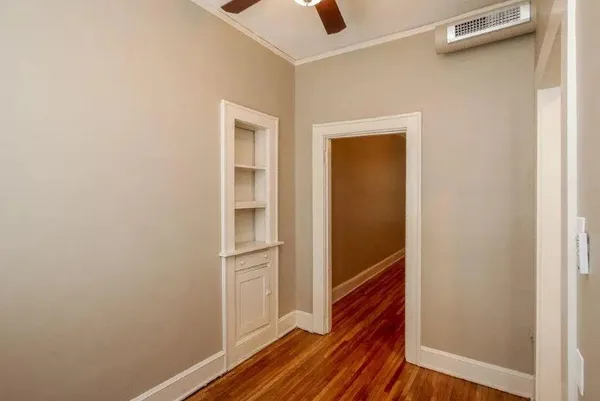 a view of a hallway with wooden floor and closet