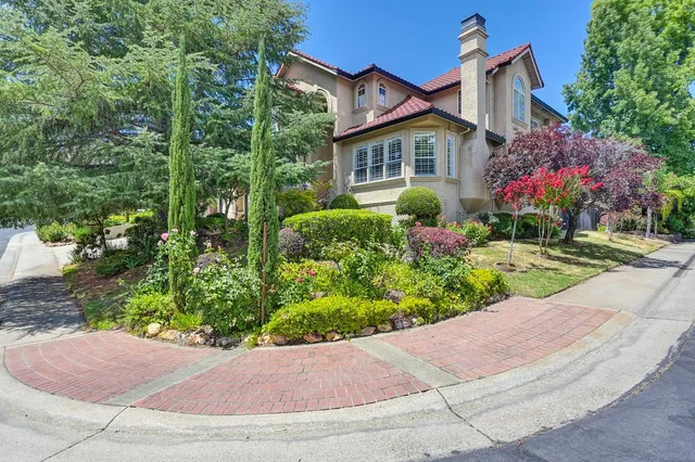 a front view of a house with a yard and potted plants