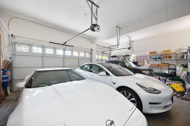 a view of swimming pool with lawn chairs and plants