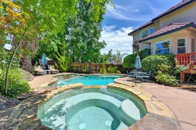 a view of a house with swimming pool and sitting area