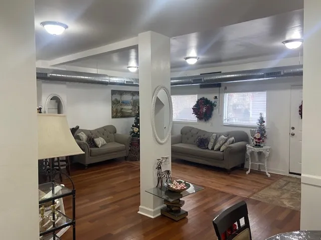 a living room with furniture and a wooden floor