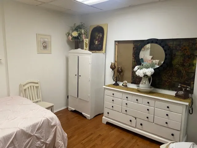 a bedroom with a bed and wooden floor