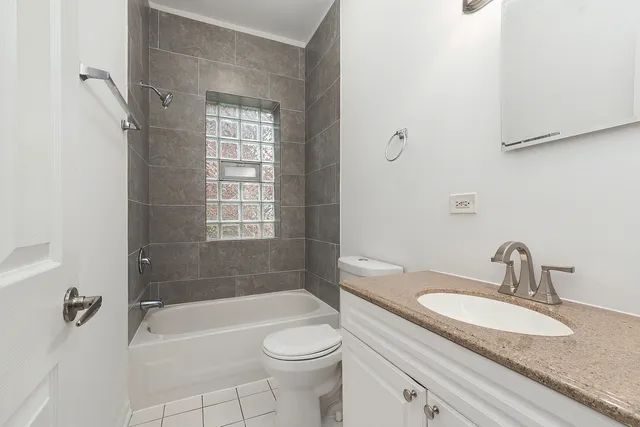 a bathroom with a granite countertop sink a toilet and bathtub