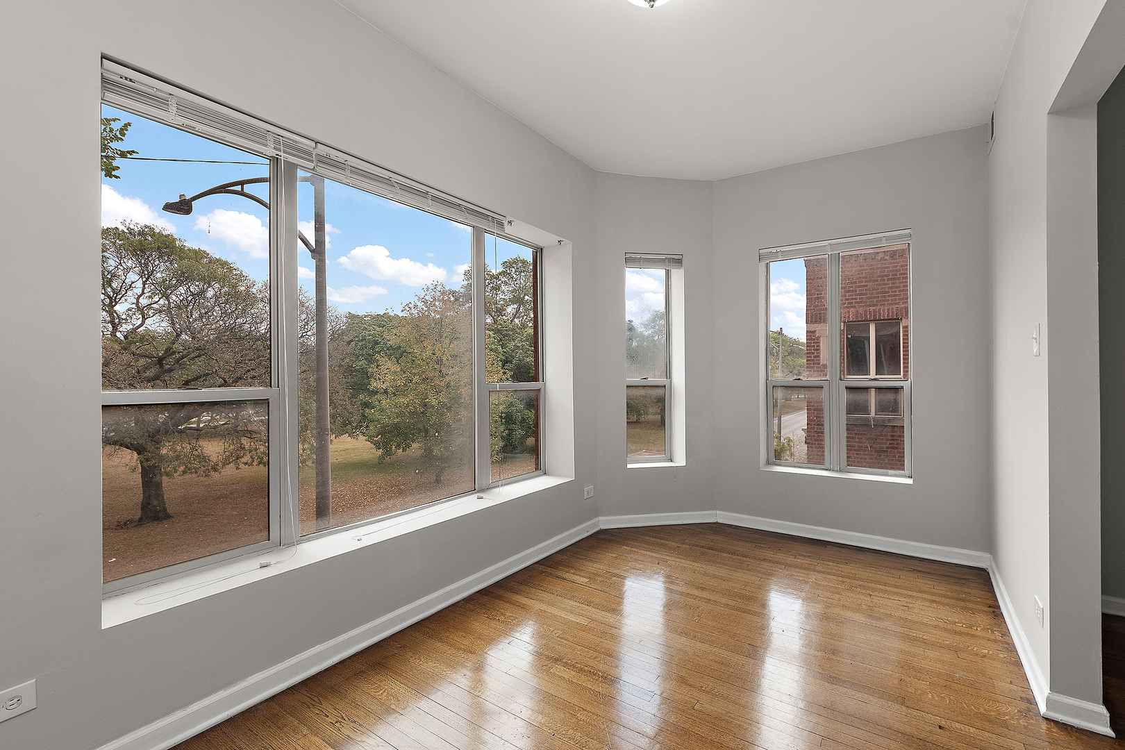 5150 South King Drive, Unit 2A Chicago, IL 60615 - Photo 8 of 22 a view of an empty room with a window and wooden floor