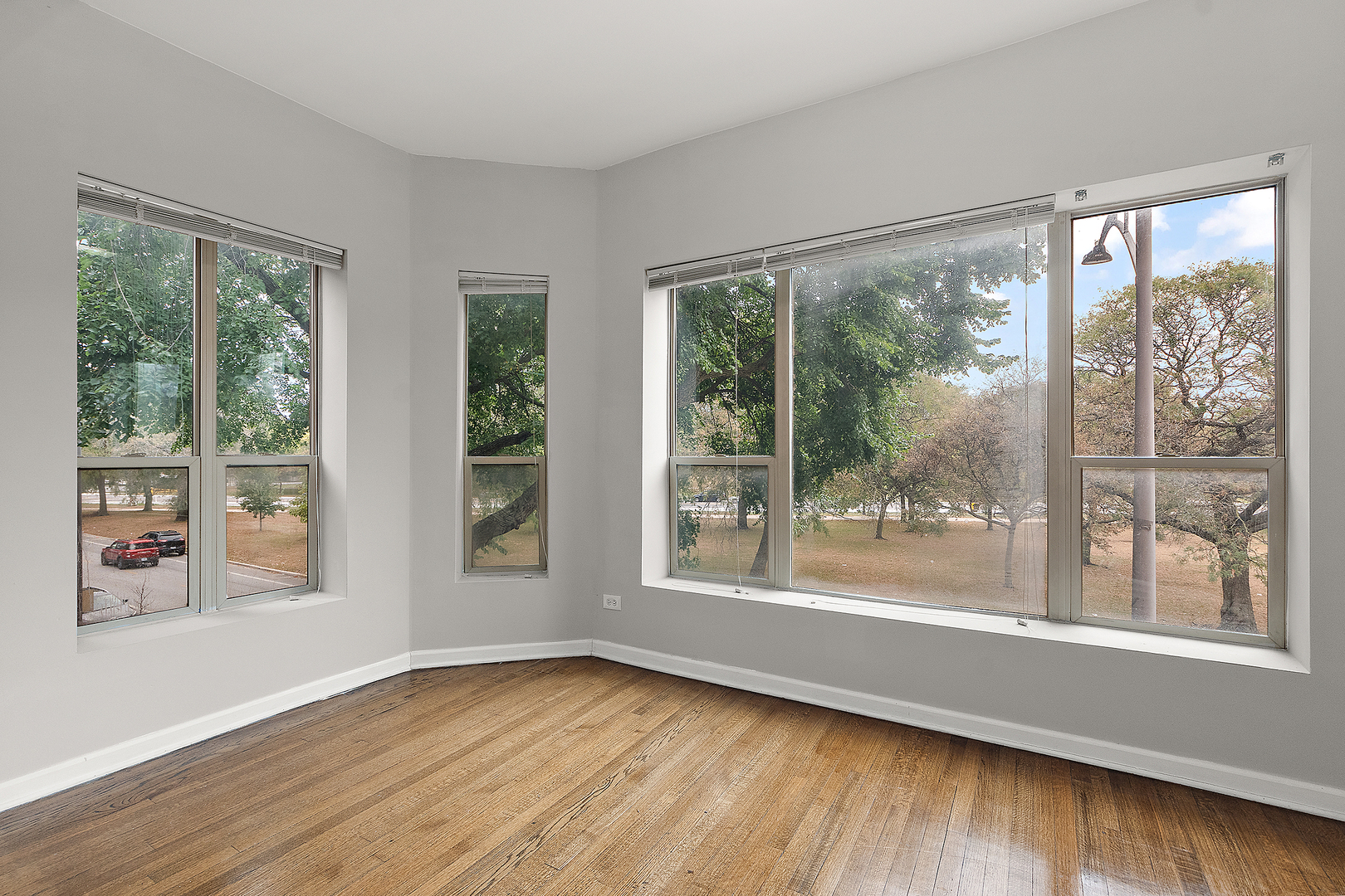 5150 South King Drive, Unit 2A Chicago, IL 60615 - Photo 10 of 22 a view of an empty room with wooden floor and a window