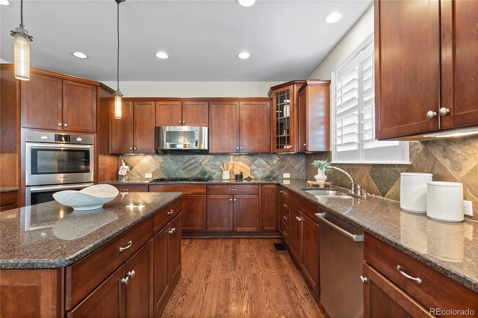 10840 Valleybrook Circle Highlands Ranch, CO 80130 - Photo 23 of 49 a kitchen with stainless steel appliances granite countertop a sink stove and cabinets