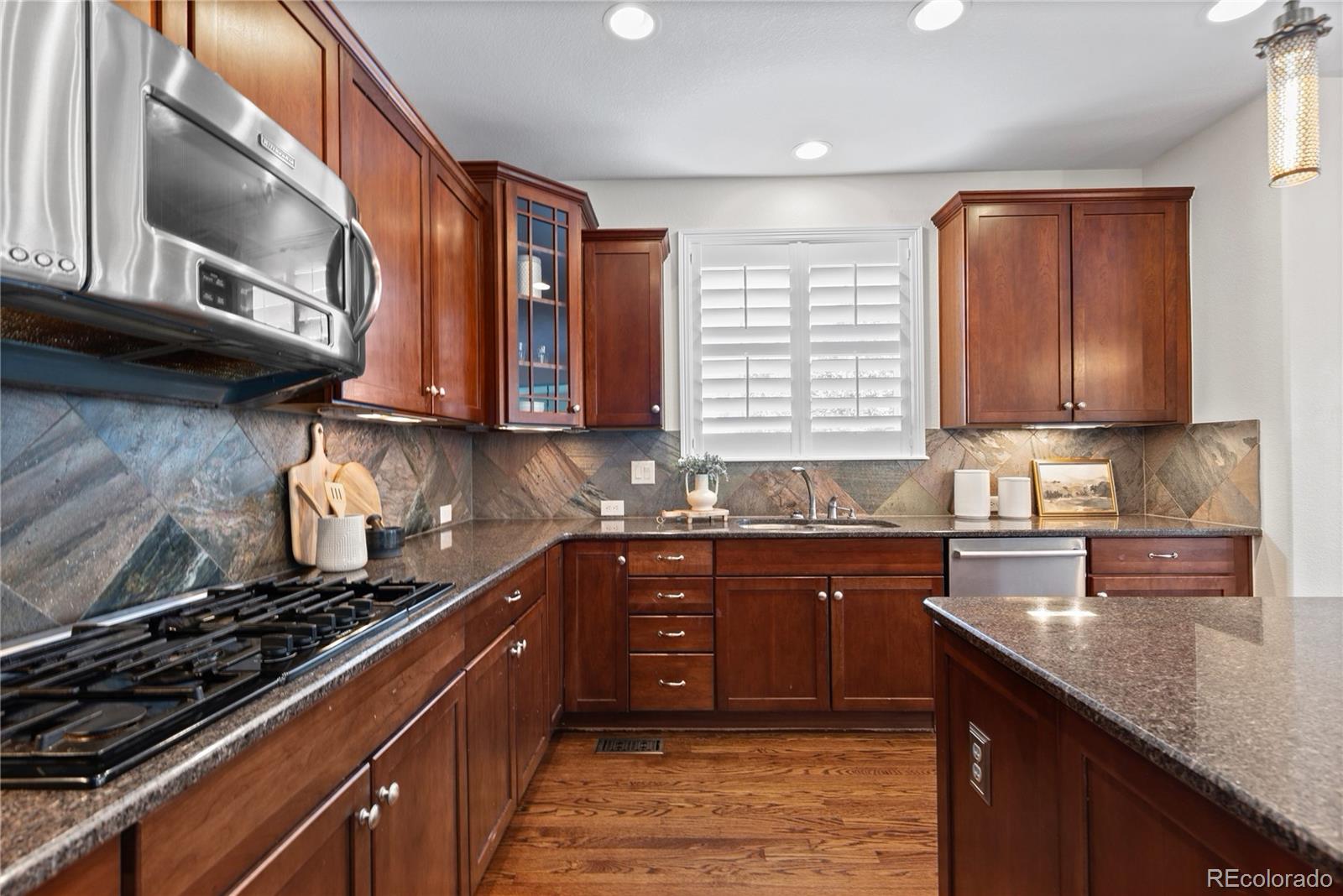 10840 Valleybrook Circle Highlands Ranch, CO 80130 - Photo 24 of 49 a kitchen with stainless steel appliances granite countertop a stove sink and cabinets