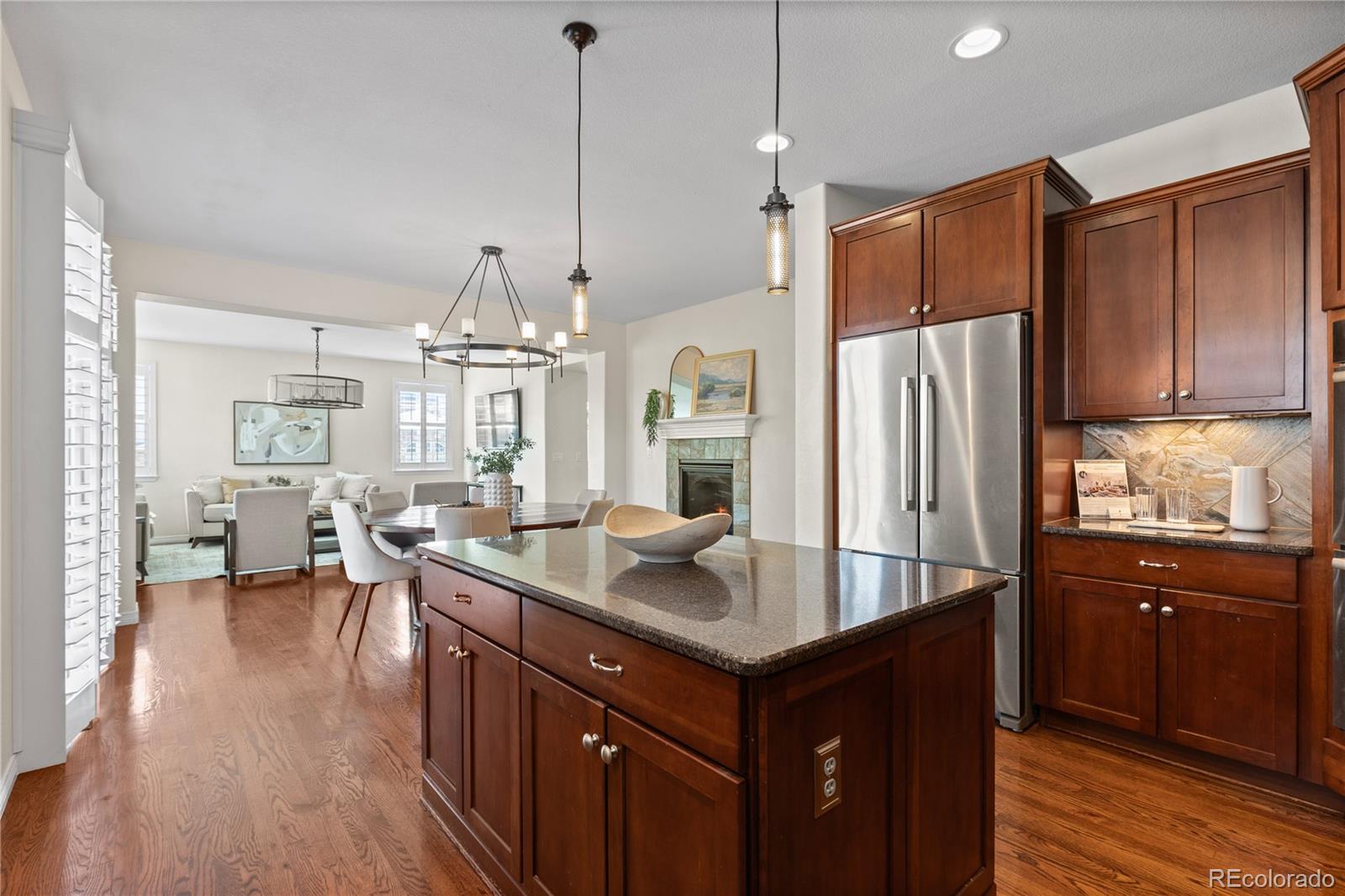10840 Valleybrook Circle Highlands Ranch, CO 80130 - Photo 25 of 49 a kitchen with stainless steel appliances granite countertop a refrigerator a sink dishwasher a oven and a dining table with wooden floor