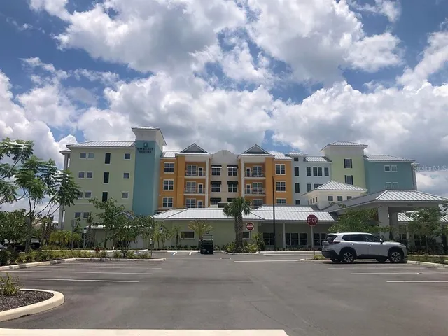 a front view of a building with street view and car parked