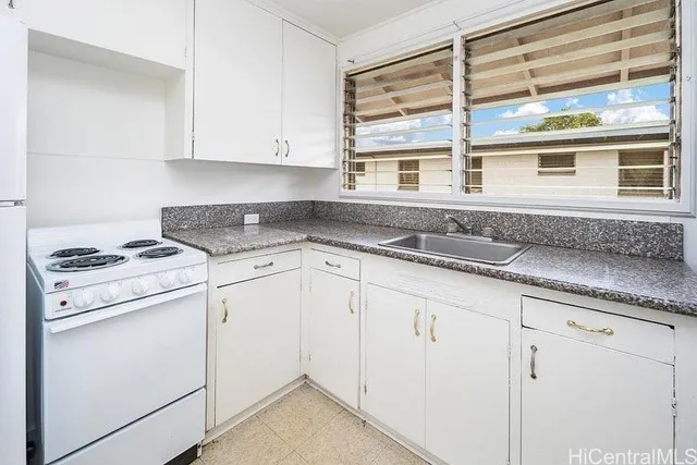 a kitchen with granite countertop white cabinets and white appliances