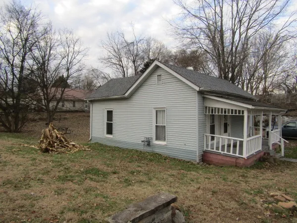 a view of a house with a yard and large tree