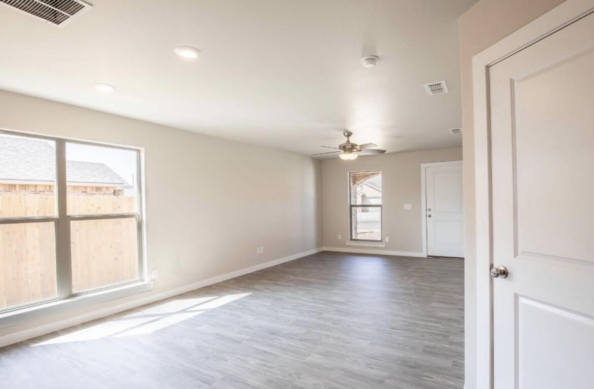 2417 144th Street, Unit B Lubbock, TX 79423 - Photo 2 of 13 wooden floor in an empty room with a window
