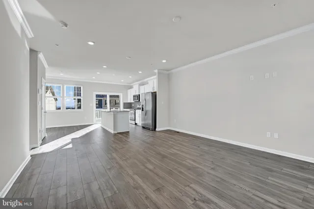 a view of a big room with wooden floor and windows