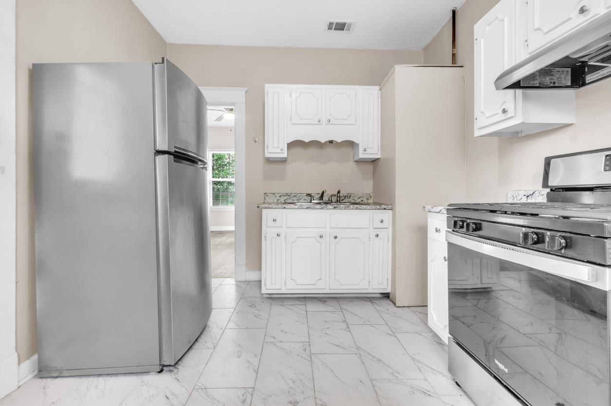 1148 Rozelle Street Memphis, TN 38106 - Photo 11 of 16 a kitchen with a stove a refrigerator and a sink